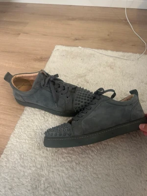 Christian Louboutin skor Grå - Säljer autletiska jätte snygga, grå röda Louboutin skor.Använda några gånger har de blivit lite slitna men fortfarande i fint skick. Men annars är det inget fel på dem. Storlek 44.Lägg gärna ett bud.