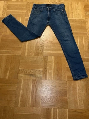 Mörkblå replay jeans med fickdetalj - Säljer ett par mörkblå replay jeans med klassisk femficksdesign och snygg söm på bakfickan. Jeansen har normal midja och smal passform hela vägen ner. Materialet är stretchigt denim som sitter bekvämt och följer kroppen.