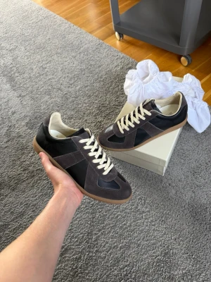 Maison margiela gats - Säljer ett par maison margiela gats i en grå svart colourway. Helt nya och alla tillbehör så som box och dustbags medföljer✅Smidig affär=pris kan sänkas. Frågor? Kontakta mig ✅Allt gott, mvh Noah