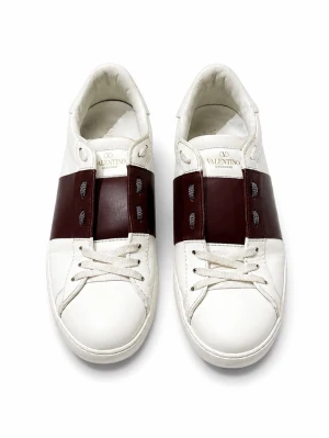 Valentino sko - Snygga vita sneakers från Valentino med breda vinröda läderdetaljer över snörningen och coola nitar på hälen. Skorna har klassisk låg profil och är tillverkade i slätt läder med vita skosnören och diskret logga på plösen.