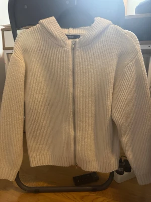 Stickad tröja - Vit Stickad cardigan med luva från Bikbok. Använt en gång. Storlek XS.