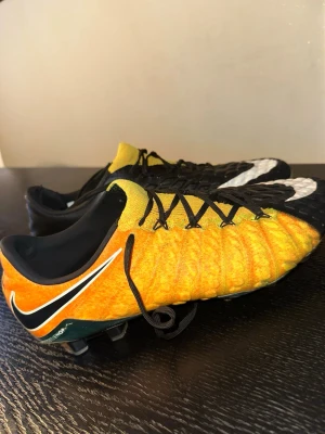 Nike Hypervenom orange/svart fotbollsskor - Säljer ett par Nike Hypervenom fotbollsskor i en grymt snygg orange och svart färg med vita detaljer. Skorna har låg profil, snörning och mönstrad ovandel för bättre bollkontroll.                     Priset kan absolut diskuteras. 