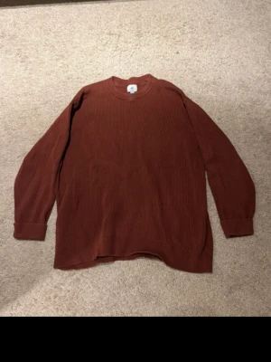 Rostbrun stickad tröja från H&M - Säljer en rostbrun stickad tröja från H&M i relaxed fit. Tröjan har rund halsringning, långa ärmar och ribbad struktur. Perfekt för dig som gillar en avslappnad och enkel stil.