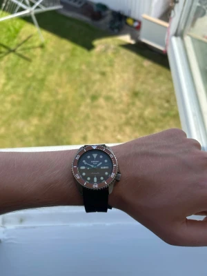 Seiko 5 sports automatisk dykarklocka svart 42mm - Seiko 5 Sports Automatic i fint begagnat skick. Fungerar utmärkt och håller tiden som den ska. Levereras med original Seiko-box och ett högkvalitativt eftermarknads Oysterflex-inspirerat gummiband. Mindre bruksspår på bezeln samt mycket små märken på glaset som knappt syns. Dag- och datumvisning fungerar perfekt. En pålitlig och snygg automatisk klocka redo för en ny ägare.