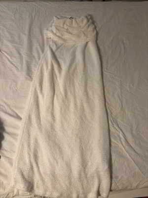 Bouclé maxikjol från Gina Tricot - Säljer en krämvit maxikjol i bouclé från Gina Tricot. Kjolen har en lång, rak passform och resår i midjan för extra komfort. Materialet är mjukt och strukturerat, vilket ger en trendig och avslappnad look. Perfekt att styla med en enkel topp eller stickad tröja.