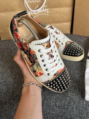 Christian Louboutin sneakers med nitar - Unika sneakers från Christian Louboutin med färgglatt grafiskt mönster, vita läderdetaljer och silverfärgade nitar på tå och häl. Skorna har vita snören och en klassisk låg siluett. Bara skorna ingår, det är 100% äkta och det står jag för hör gärna av er vid minsta fundering eller intresse. Kan gå ner i pris vid snabb affär😄