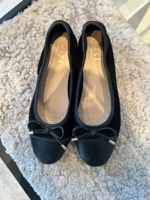 Svarta ballerinaskor  - Stilrena svarta ballerinaskor från Pace med rund tå och dekorativ rosett. Skorna är slutsålda på din skos hemsida nypris 600kr. Köpte dem nya och använt dem 3 gånger. Jag säljer pga att dem inte passar!💖💖