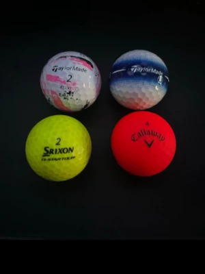 Färgglada golfbollar från TaylorMade - Fyra golfbollar i olika färger och märken: vit/rosa och blå/vit från TaylorMade, gul från Srixon och röd från Callaway. Perfekta för dig som vill sticka ut på golfbanan. Klassisk rund form och tillverkade i slitstarkt material.