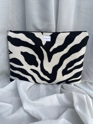 Datorfodral zebra svart vit - Laptopfodral i snyggt möbeltyg med stort zebramöster. Brunt innertyg och matchande svart dragkedja. Passar laptop med maxmått: 32x24cm