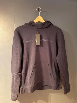Mörkblå hoodie från Sail Racing - sprillans nya!! aldrig använd, endast testat en gång. Pris går att diskutera vid snabbare äffär