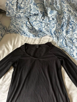 Svart ribbad långärmad topp Lindex  - Svart långärmad topp från Lindex  med ribbad struktur och v-ringad halsringning. Snygg och enkel modell som passar till mycket. Perfekt att styla med jeans eller kjol. Vill bli av med, köptes för 300 