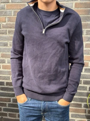 Mörkblå halvzip tröja - Snygg mörkblå tröja med halv dragkedja och ståkrage. Tröjan har diskret struktur i materialet, ribbade muddar vid ärmslut och nederkant samt en avslappnad passform. Perfekt till jeans för en clean look.. Skriv gärna vid frågor! Modell:180/70kg
