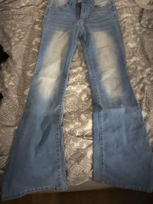 Ljusblå bootcut jeans med bling - Säljer ett par ljusblå bootcut jeans med bling på baksidan dem är väldigt stretchiga och passar till allt