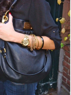 Svart handväska i skinn från Marc Jacobs - Snygg svart handväska i mjukt skinn från Marc Jacobs. Väskan har en rundad form, guldfärgad logoplatta framtill och både axelrem och handtag. Perfekt storlek för att få plats med allt du behöver och passar till många olika stilar. Perfekt till skolan! Läkta läder skriv för fler bilder 🌸