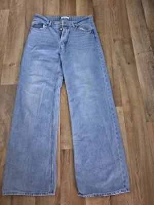 H&M hög midja vida jeans typ nya - Snygga ljusblå jeans med hög midja,dvs lagom "hög"midja och vida nedtill knappt använda så i nytt mycket bra skick st 36