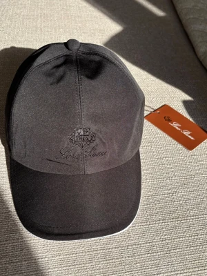 Svart keps från Loro Piana - Helt ny och oanvänd Loro Piana keps i svart. Aldrig använd och i perfekt skick. Skicka gärna meddelande vid intresse!