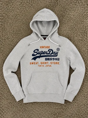 Superdry Hoodie Grå - Superdry Hoodie Grå - Väldigt fint och fräscht skick. - Storlek: XL men sitter exakt som en M. - Pris: 599kr - Först till Kvarn!