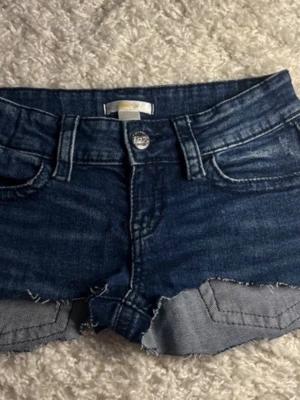Mörkblå jeansshorts - Snygga mörkblå jeansshorts med  fransig kant och klassisk femficksdesign. Klippta från ett par jeans. 