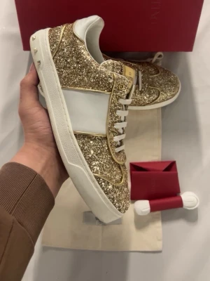 Valentino Flycrew - Säljer ett par [märke + modell] i fint skick. Storlek: 38 Skick: 9/10 Färg: Guld glittriga Pris: 3000 kr Snabb affär prioriteras – seriösa bud välkomna. Skriv gärna för fler bilder eller frågor. Kan posta snabbt🥰