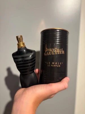 Jean Paul Gaultier Le Male Parfym - Säljer en Jean Paul Gaultier Le Male Le Parfum. Flaskan har en unik design i form av en svart manlig torso med guldigt sprayhuvud och svarta ränder. Kommer med originalförpackning i svart metall och röd sammetsbas. Perfekt för dig som gillar exklusiva dofter.