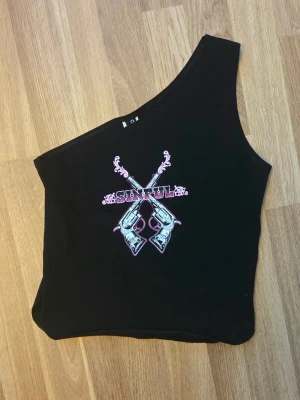 Sinful topp med en ärm - Snygg topp med tryck från Sinful, en ärm.
