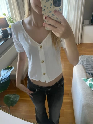 Vit blus med knappar - Söt vit blus med v-ringning och stora  knappar framtill. I storlek xs från HM och i bra skick. 💕