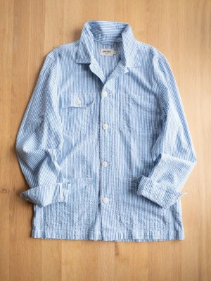 Seersucker Chore Jacket, size M - Säljer en blåvit overshirt med ränder och stora vita knappar. Skjortan har lång ärm, klassisk krage och flera fickor framtill. Tillverkad i mjuk bomull med avslappnad passform, perfekt för lager på lager.