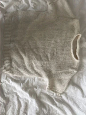 Vit stickad kortärmad tröja - Mysig vit stickad tröja med korta ärmar och rund hals. Har klippt bort lappen men skulle gissa på xs/s! Varan e lite nopprig!