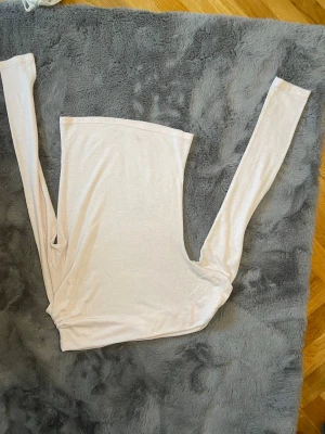 Ljusbeige långärmad topp från Nelly - Säljer en ljusbeige långärmad topp från Nelly. Toppen är enkel och stilren med rak passform och mjukt material, perfekt att matcha med jeans eller kjol. Ärmarna är långa och tyget känns lätt och bekvämt mot huden.