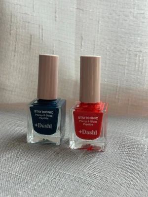 2x Dashl Stay Iconic Nagellack (Nya & Oöppnade) - Säljer två helt nya och oöppnade nagellack från Dashl i serien Stay Iconic Plump & Gloss Peptide. Ett i en mörkt blå nyans och ett i en röd nyans. 