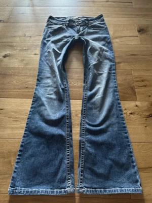 Lågmidjade vintage bootcutjeans med snygga detaljer på fickorna - Jättesnygga lågmidjade vintage bootcutjeans med snygga detaljer på fickorna. Jeansen är köpta på H&M 2006 eller 2007 så jeansen är väldigt rare. Ingen storlek i lappen men passar XXS/32/XS/34.  Midjemått tvärsöver: 35 cm. Innerbenslängd: 75 cm.