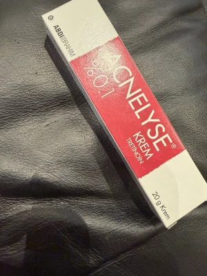 Acnelyse Krem 0.1% Tretinoin 20g - Acnelyse Krem 0.1% med tretinoin är en kräm i tub på 20g, perfekt för hudvård och behandling av akne. Förpackningen är vit och röd med tydlig märkning. Krämen är populär för sin effektiva formula.