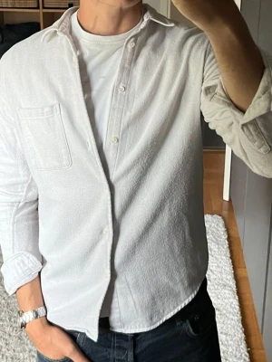 Samsøe Samsøe flanellskjorta i beige - stl M - Samsøe Samsøe flanellskjorta i beige, storlek M. 100% ekologisk bomull i portugisisk flanell, mjuk och lite tjockare, funkar både som skjorta och som lätt överskjorta. Bröstficka och avrundad nederkant. Personen på bilden är 189cm, väger 78kg.  Använd men i mycket fint skick, inga hål eller fläckar.  Rök- och djurfritt hem. Skriv gärna om du vill ha fler bilder eller undrar något!
