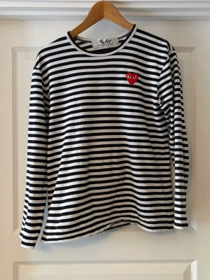 PLAY Comme Des Garçons tröja - Fin tröja PLAY Comme Des Garçons, storlek M i väldigt bra skick. Det är ett hål baktill där lappen är fäst men det är bara det!