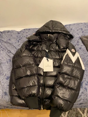 Svart Moncler pufferjacka  - Säljer en svart pufferjacka från Moncler Fodrad och riktigt varm, perfekt för kalla dagar. Snygg. Har använt en gång i skolan tills jag märkte att den var för stor. Skriv för mer information har mycket om jacka. Köpt 12 tusen. Våga ge prisförslag