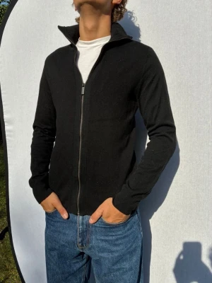Perry Ellis kofta S - Hej och välkommen till byTorén. Detta är en kofta från Perry Ellis i storlek S med normal passform. Modell på bild är ca 182, 67kg. Plagget är i bra skick utan några defekter. Tveka inte på att höra av dig, även om det skulle vara minsta lilla;)