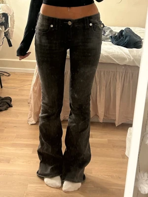 Gråa lågmidjade True Religipn bootcutjeans - Säljer ett par gråa jättefina bootcut jeans med låg midja från True religion! Supersnygga detaljer och perfekta nu till hösten🤩Dom är ljusare grå än vad som syns på bilden! Köpt på Nelly för ca 1200kr och använda ca 4ggr så i princip nya. Öppen för prisförslag!