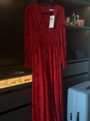 Adoore - Napoli Maxi Red   -  Lång Adoore klänning i djup röd . Klänningen har v-ringning, långa ärmar och markerad midja. Helt ny, oanvönd och har lappar på. Ordinarie pris: 1695kr, säljer den för 945 kr  då den inte passade mig. 