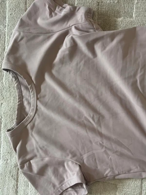 Ljusbeige kortärmad t-shirt - En stilren ljusbeige t-shirt i mjukt material. T-shirten har rund halsringning och korta ärmar, perfekt för en enkel och clean look. Passar till det mesta och är lätt att matcha med andra plagg.