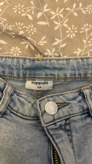 Ljusblå jeansshorts - Säljer ett par ljusblå jeans med klassisk femficksdesign och raka ben. Jeansen har en enkel bakficka utan detaljer och är tillverkade i mjuk denim. Perfekta för en avslappnad och trendig look. Säljs då den blivit försmå