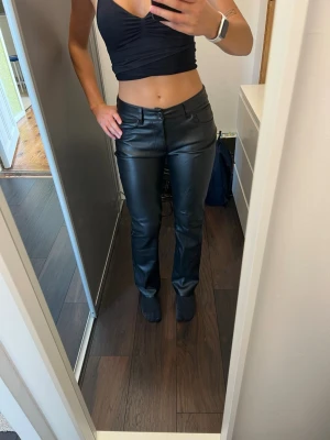 Svarta raka skinnbyxor - Snygga svarta skinnbyxor från bikbok som är använts väl på fest och är därför lite slitna vilket syns på bilderna. 