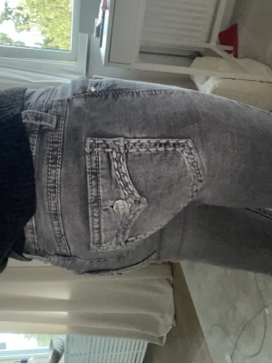 Grå raka jeans med fickdetaljer - Säljer ett par grå jeans med raka ben och snygga fickdetaljer bak med silverknappar. Jeansen har klassisk femficksmodell och bälteshällor. Perfekta till en avslappnad stil och passar till det mesta i garderoben. Dom sitter för tajt på mig det är farföräldrar jag säljer dom. Skriv om ni har några frågor!💕