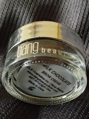 Bang Beauty Milk Chocolate Brow Cream - Ögonbrynskräm från Bang Beauty i färgen Milk Chocolate. Kommer i en liten rund glasburk med guldfärgat lock. Perfekt för att forma och fylla i brynen med en naturlig brun ton. Krämig formula som är enkel att applicera för ett snyggt resultat.