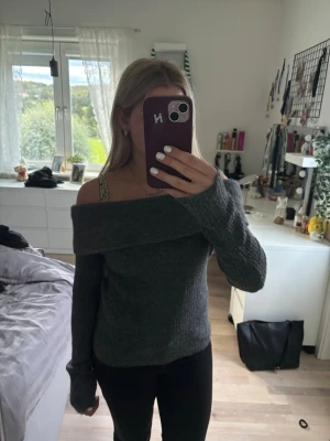 Grå off shoulder stickad tröja - Mysig grå stickad tröja med off shoulder-design och långa ärmar. Tröjan har bred krage som viks ner över axlarna och är ribbstickad för extra komfort. Perfekt inför hösten 🍁 aldrig använt den 💕