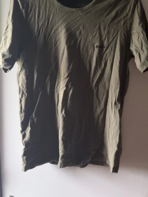 Grön t-shirt från BOSS - Bra skick, hittade tröjan i samband med flytt och glömde bort att jag ens har haft den, knappt använd bara legat i garderoben (därav skrynklig)