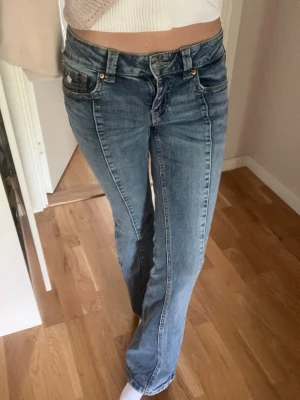 Lågmidjade bootcut jeans från Gina Tricot - Snygga blå bootcut jeans från Gina Tricot med klassisk femficksdesign och broderad bakficka. Jeansen är lågmidjade och är tillverkade i denim med lätt stretch för skön passform. Råkade av misstag köpa i en för liten storlek, så de är helt i nyskick, men utan prislapp. Går jättebra att diskutera pris. Storlek 36🤗💗