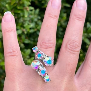 Silverpläterad ring kristaller - Mixed Sized Halo Ring, i silverpläterad mässing med kristaller. Ss 29 6mm, ss39 8mm och ss24 5mm. Färg Aurora Borealis. Ställbar storlek. De sista bilderna visar andra färger och modeller som finns i lager.  Jag skickar endast spårbart, samfraktar. Fast pris. Besök gärna mina övriga annonser.  Till mina smycken använder jag kristaller från Preciosa, Aurora och Swarowski.
