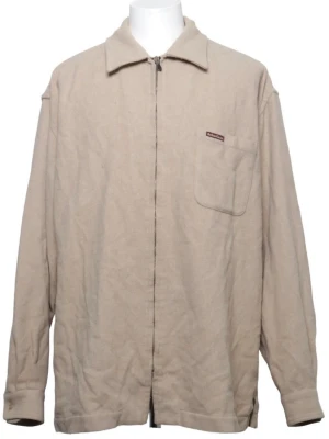 Marlboro overshirt   - Stilren beige overshirt med dragkedja framtill och en enkel bröstficka. Overshirten har klassisk krage och raka ärmar. Materialet ser ut att vara mjukt och lite tjockare, perfekt för lager på lager. Passar till många olika stilar. Kolla bilder för nopprig och färgskada.