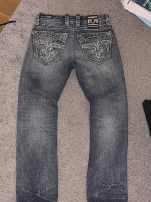 Rock Revival Jeans - Hej! Säljer ett par Rock Revivals som knappt kommit till användning. Ser grå ut på första bilden men är egentligen ljusblå. Dm om du har några frågor!                         Priset är ej hugget i sten 
