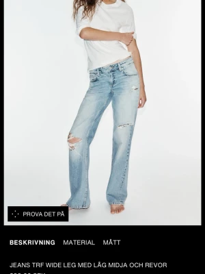 Ljusblå wide leg jeans med revir - Säljer ett par ljusblå jeans med wide leg och låg midja. Jeansen har slitna detaljer och revor på benen för en trendig, avslappnad look. Klassisk femficksmodell och raka ben. Perfekta för dig som gillar en chill och modern stil. Kommer inte sälja för mindre än 300 eftersom den är helt ny
